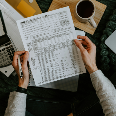 Hands reviewing a completed personal tax return form with a calculator nearby